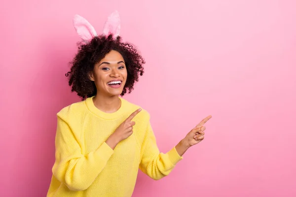 Zdjęcie dość urocza kobieta ubrana zestawy pullover Wielkanoc opaska wskazując puste miejsce odizolowane różowy kolor tło — Zdjęcie stockowe