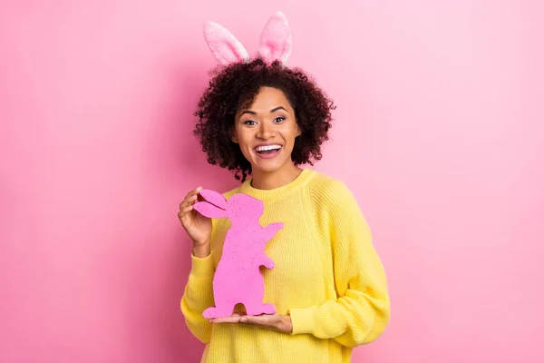 Zdjęcie dość podekscytowany kobieta ubrana zestawy pullover Wielkanoc opaska gospodarstwa królik odizolowany różowy kolor tło — Zdjęcie stockowe