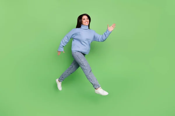 Fénykép a bájos édes nő viselni kék pulóver fut gyorsan ugrás magas elszigetelt zöld színű háttér — Stock Fotó