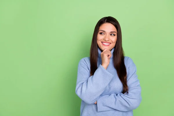 Foto de mujer joven bonita reflexiva usar suéter azul sonriendo buscando espacio vacío brazo barbilla aislado color verde fondo — Foto de Stock