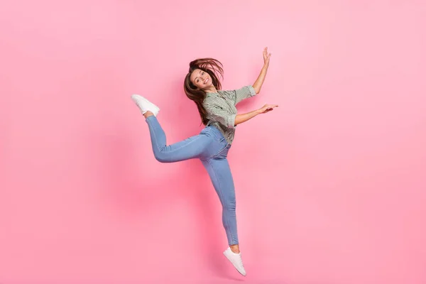 Foto de longitud completa de dulce millennial dama morena salto ropa jeans zapatillas aisladas sobre fondo de color rosa — Foto de Stock