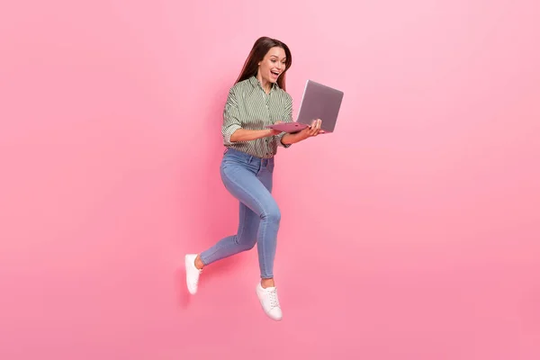 Foto di divertente donna eccitata indossare camicia a righe digitando dispositivo moderno salto alto isolato colore rosa sfondo — Foto Stock