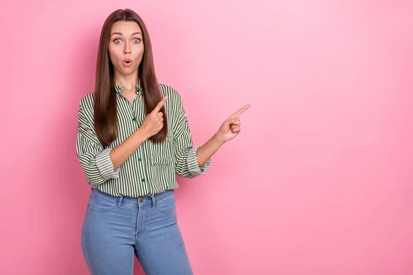 Foto van opgewonden geschokte dame directe wijsvingers lege ruimte dragen gestreept groen shirt geïsoleerde roze kleur achtergrond — Stockfoto