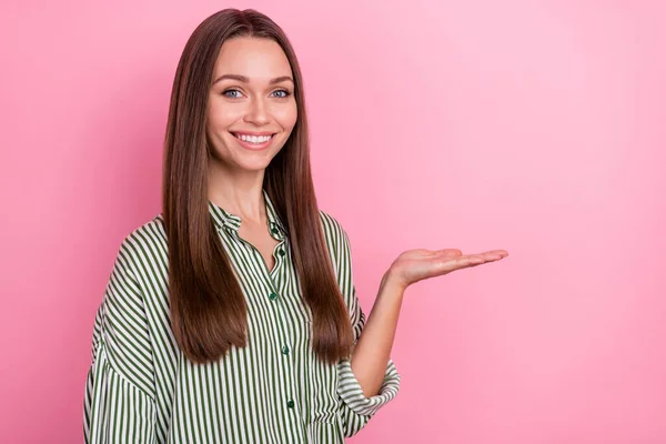 Foto de la mujer adorable divertida usar camisa a rayas sosteniendo el brazo espacio vacío aislado color rosa fondo —  Fotos de Stock
