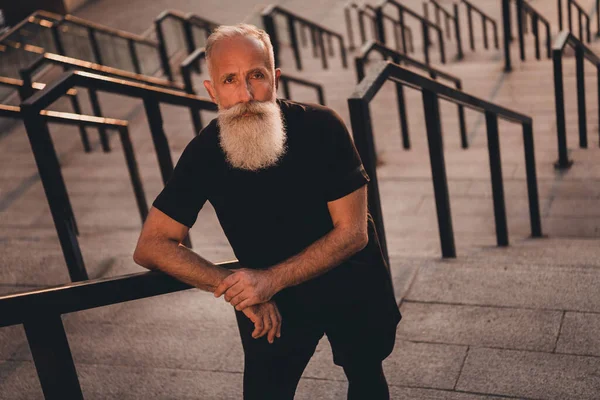 Photo de graves concentrés pensionné entraîneur homme debout escalier fort porter t-shirt ville urbaine en plein air — Photo