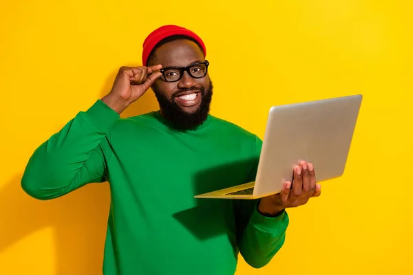 Portret atrakcyjnej wesoły twórczy facet projektant stron internetowych za pomocą laptopa dotykając specyfikacje izolowane na jasnożółtym tle koloru — Zdjęcie stockowe
