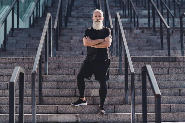 Full length photo of aged white hair strong man folded arms φορούν μαύρα t-shirt sneakers έξω στην πόλη — Φωτογραφία Αρχείου