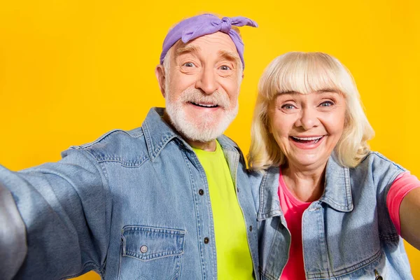 Φωτογραφία του πολύ χαριτωμένο συνταξιούχος σύζυγος φορούν τζιν ρούχα λαμβάνοντας selfie απομονωμένο κίτρινο χρώμα φόντο — Φωτογραφία Αρχείου