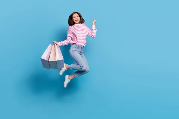 Foto de cuerpo completo de hooray millennial bob hairdo lady hold bags salto gritar desgaste jersey jeans calzado aislado sobre fondo azul — Foto de Stock