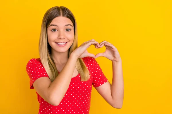 Foto de menina linda jovem mostrar figura do coração namorada romântica cupido isolado sobre fundo de cor amarela — Fotografia de Stock