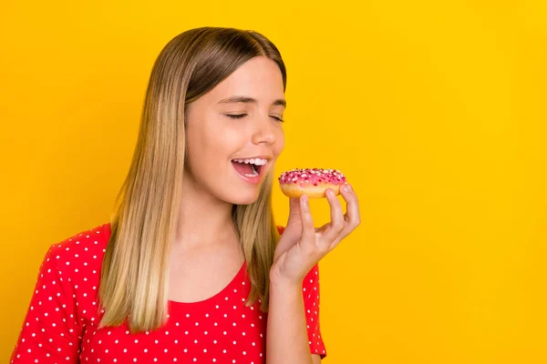Perfil da foto lateral da jovem senhora alegre mordida paz de massa de donut gostoso isolado sobre fundo de cor amarela — Fotografia de Stock