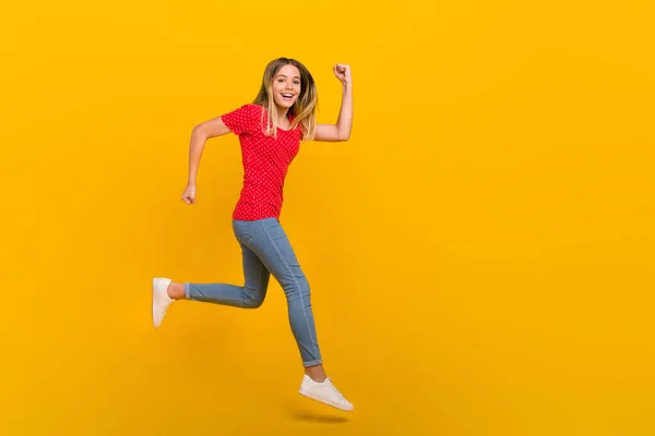 Perfil de tamaño completo lado de la foto de la muchacha joven corredor prisa movimiento velocidad salto descuento aislado sobre fondo de color amarillo — Foto de Stock