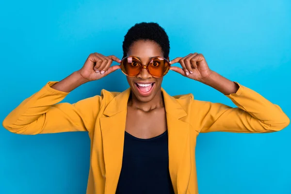 Porträtt av förvånade glada funky person händer beröring glasögon öppen mun isolerad på blå färg bakgrund — Stockfoto
