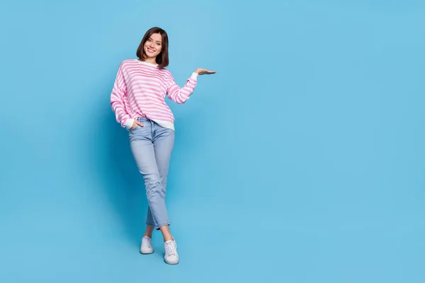 Full size foto di ottimista millenaria signora stand hold promo usura camicia jeans scarpe isolate su sfondo blu — Foto Stock