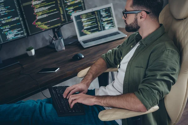 Foto de cara jovem ocupado positivo vestido óculos de camisa cáqui escrita software de dados gadget moderno em casa oficina estação de trabalho — Fotografia de Stock