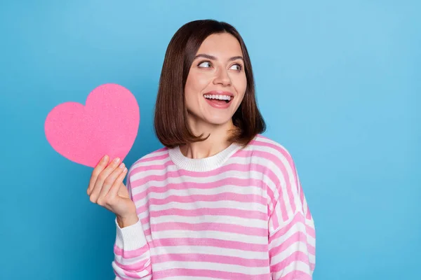 Foto de bonito jovem morena senhora segurar coração olhar promo desgaste pulôver isolado no fundo azul — Fotografia de Stock