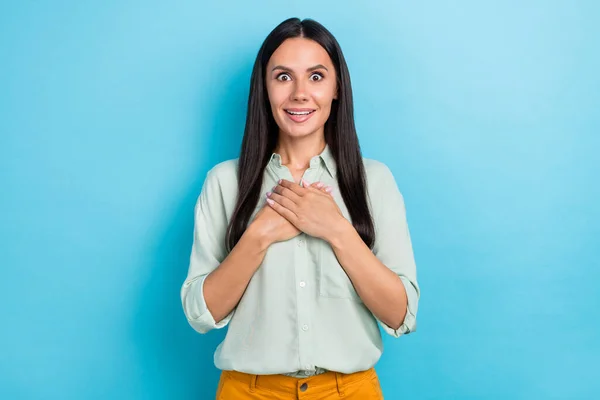 Foto de las manos de la señora joven excitada en la cara del pecho reacción agradecida aislado sobre fondo de color azul — Foto de Stock