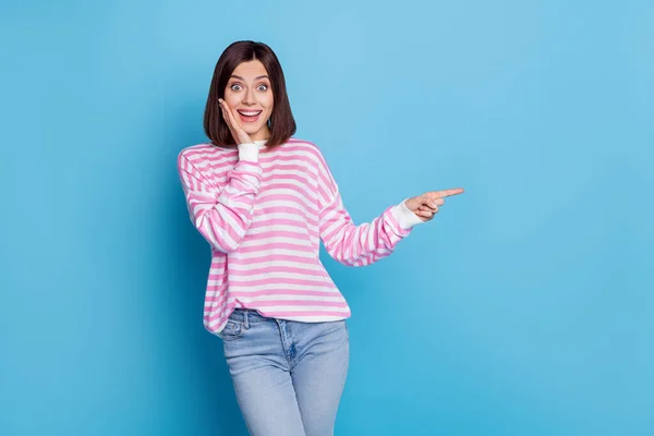 印象的な若いブルネットの女性の写真は、青い背景に隔離されたプロモーションウェアシャツジーンズを示す — ストック写真