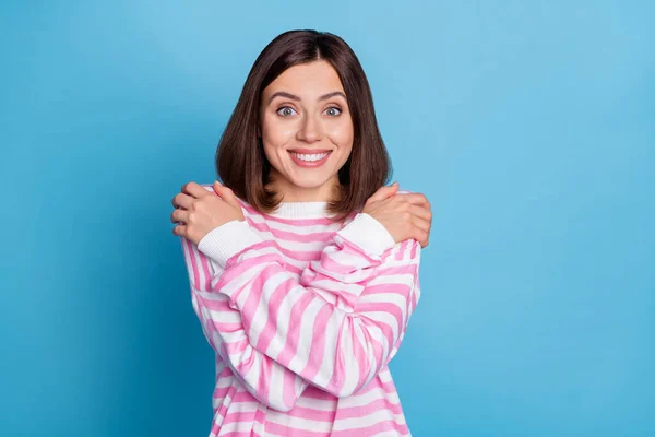 Fotografie roztomilé mladé brunetky dáma objetí sama nosit růžový jumper izolované na modrém pozadí — Stock fotografie