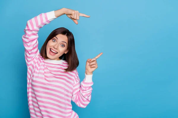 Фото возбужденной веселой дамы одетых розовый пуловер указывая пустое пространство изолированный синий цвет фона — стоковое фото