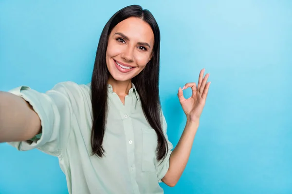 Foto de jovem senhora alegre mostrar dedos okey símbolo bom bom promo tomar selfie isolado sobre fundo de cor azul — Fotografia de Stock