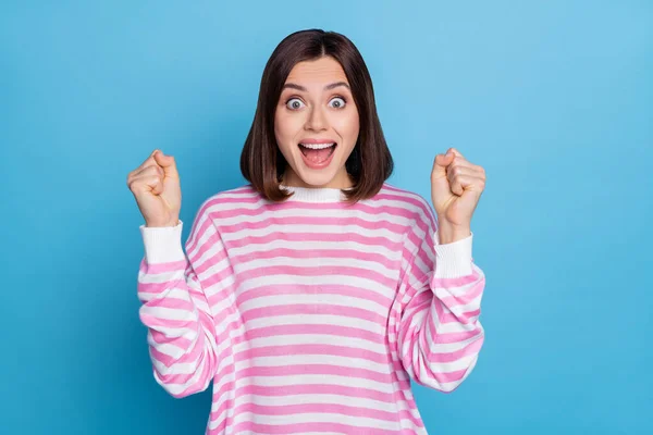 Foto de mulher sortuda engraçada usar listrado suéter levantando punhos gritando isolado azul cor de fundo — Fotografia de Stock
