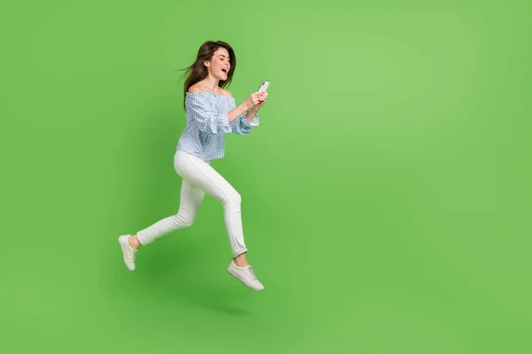 Zdjęcie podekscytowanej kobiety nosić kratę off-ramiona bluzka skoków wysoki gadżet rozmowy puste miejsce odizolowane zielony kolor tło — Zdjęcie stockowe
