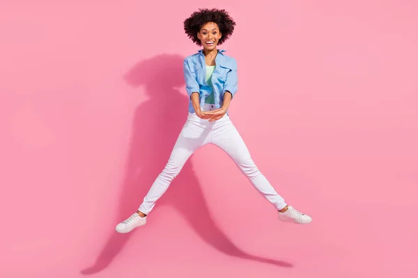 Fotografie okouzlující charismatické rád dáma skok držet dlaně těšit víkend nosit džínové košile kalhoty tenisky izolované růžové barvy pozadí — Stock fotografie
