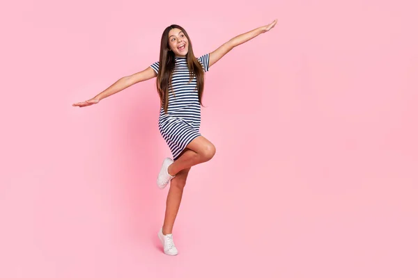 Foto de chica brillante dulce usar vestido a rayas caminando bailando buscando espacio vacío aislado color rosa fondo —  Fotos de Stock