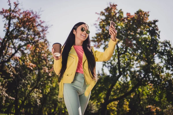 Fotografie atraktivní bezstarostné cool dáma držet papír odnést šálek, aby selfie těšit sluneční paprsky volný čas venku — Stock fotografie