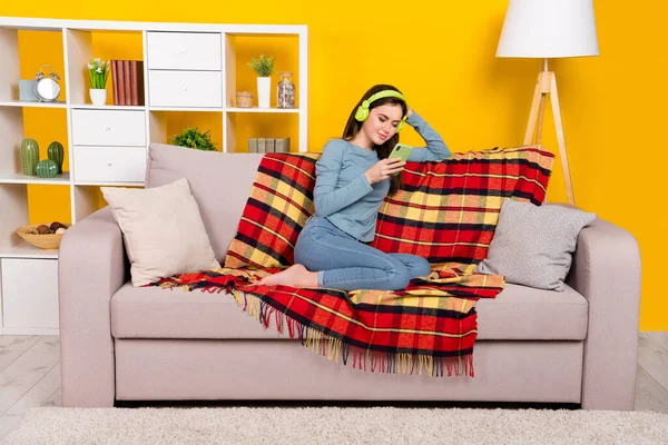 Plná velikost fotografie pozitivní klidné dáma sedět bosá gauč použití telefonu izolované na žlutém pozadí — Stock fotografie