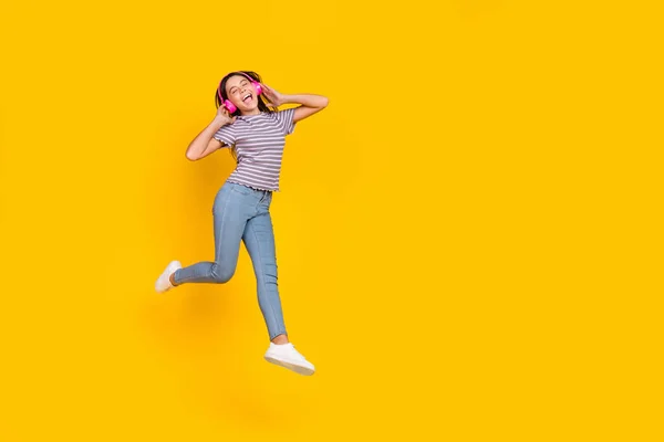 Pleine longueur photo de jeune fille excité profiter de musique écouteurs mélodie marcher isolé sur fond de couleur jaune — Photo