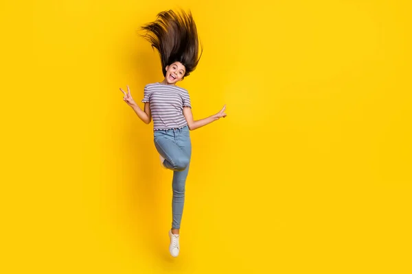 Foto de comprimento total de jovem animado salto menina mostrar dedos paz v-símbolo isolado sobre cor amarela fundo — Fotografia de Stock