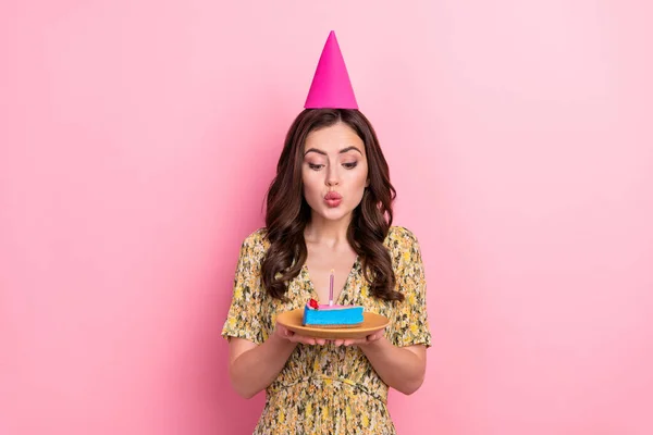 Foto di divertente signora tenere pezzo torta soffiare candela respiro isolato su sfondo di colore rosa — Foto Stock