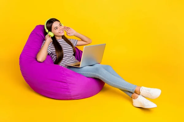 Foto samping profil gadis muda bermimpi menikmati laptop headphone radio nyaman beristirahat terisolasi dengan latar belakang warna kuning — Stok Foto