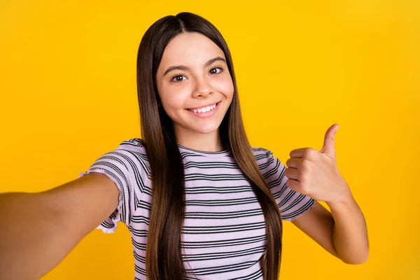 Фотографія молодої милої дівчини, яка стріляє селфі показати великий палець до ідеального вибору реклами ізольовано на жовтому кольоровому фоні — стокове фото