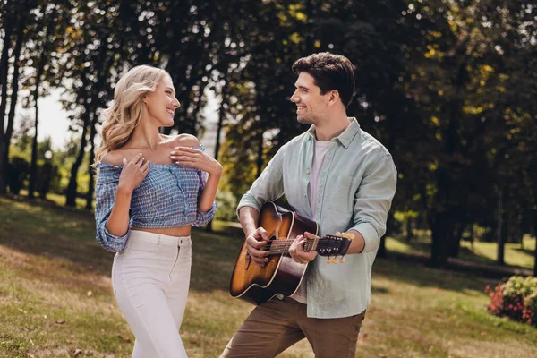 Portret van twee aantrekkelijke vrolijke paar man spelen gitaar vakantie met plezier buiten — Stockfoto