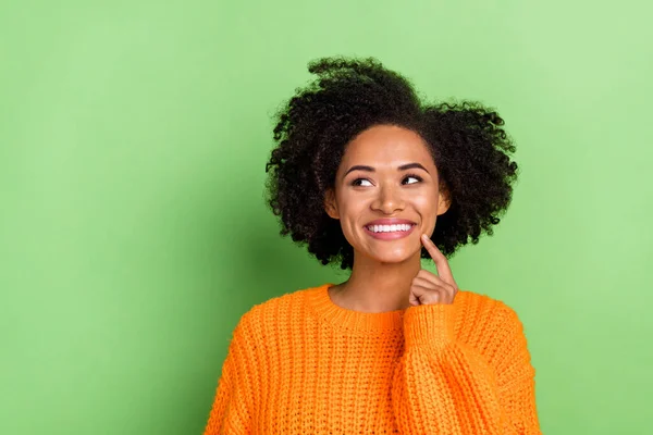 Fénykép az édes fiatal göndör frizura hölgy néz üres tér viselni narancssárga pulóver elszigetelt zöld színű háttér — Stock Fotó