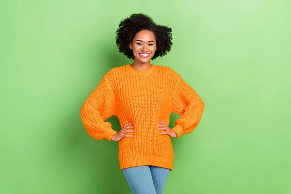 Φωτογραφία από γλυκό millennial σγουρά hairdo κυρία φορούν πορτοκαλί jumper τζιν απομονώνονται σε πράσινο φόντο χρώμα — Φωτογραφία Αρχείου