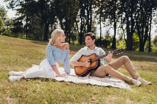 Portret van twee aantrekkelijke vrolijke paar idyllische harmonie zittend op geruite zang lied romantiek op frisse lucht buiten — Stockfoto
