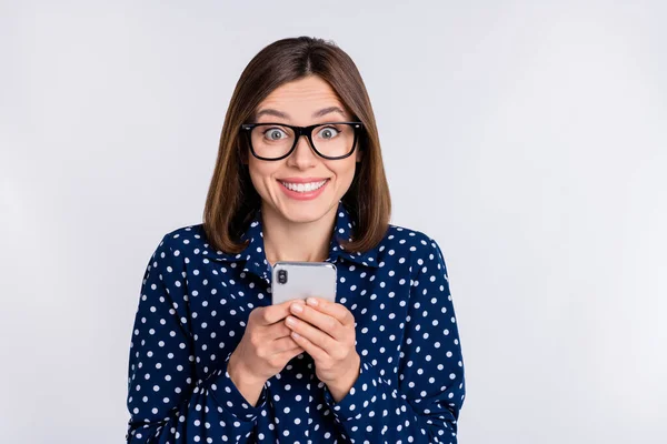 Foto de alegre animado senhora segurar telefone desfrutar de feedback desgaste blusa pontilhada isolado fundo cor cinza — Fotografia de Stock