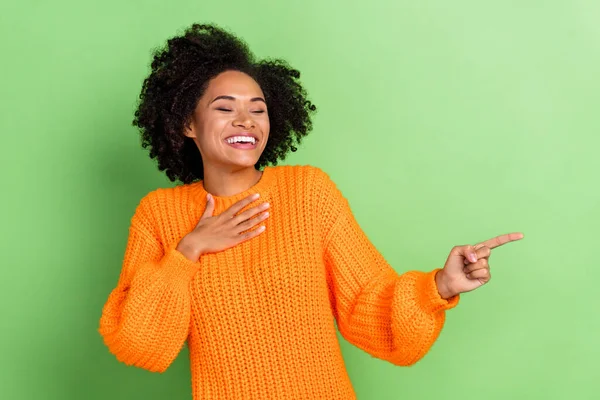 Фото сладкий молодой объем волос леди индекс промо носить оранжевый свитер изолированы на зеленом фоне — стоковое фото
