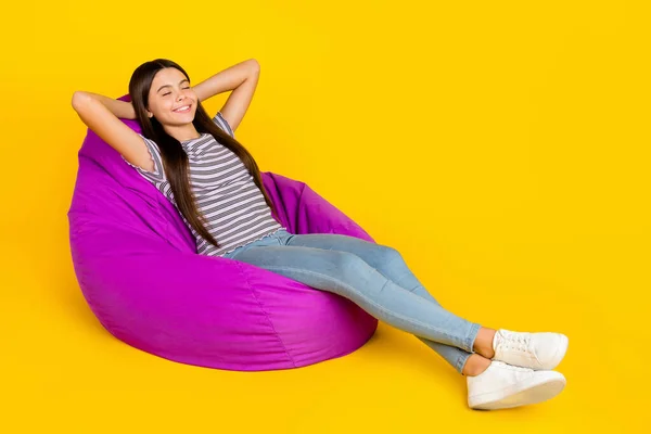 Full size profile side photo of young girl dreamy hands behind head relax soft violet chair isolated over yellow color background — Stock Photo, Image