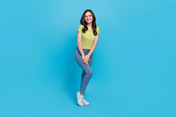 Full size photo of funny millennial brunette lady stand wear t-shirt jeans sneakers isolated on blue background — Stock Photo, Image