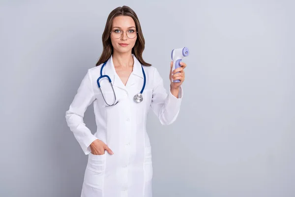 Foto der jungen Frau verwenden Thermometer Schutz covid Kinderarzt isoliert über graue Farbe Hintergrund — Stockfoto