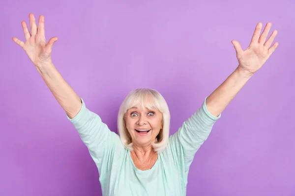 Foto di eccitato divertente pazzo positivo signora alzare le braccia bocca aperta indossare teal shirt isolato colore viola sfondo — Foto Stock