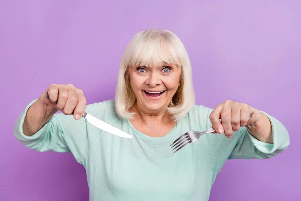 Photo of excited funky lady hold knife fork anticipate feast delicious food wear teal shirt isolated violet color background — Stock Photo, Image