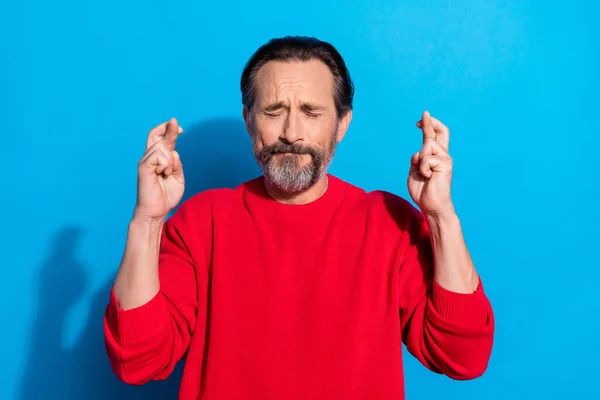 Portrait of funky stressed closed eyes mature man praying crossed fingers wish luck isolated on blue color background — Stock Photo, Image