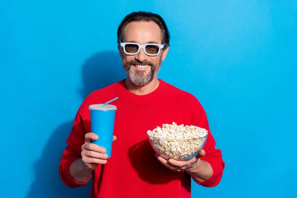 Photo of cool funky cheerful guy relaxing in cinema drinking beverage enjoying snack isolated on blue color background — Stock Photo, Image