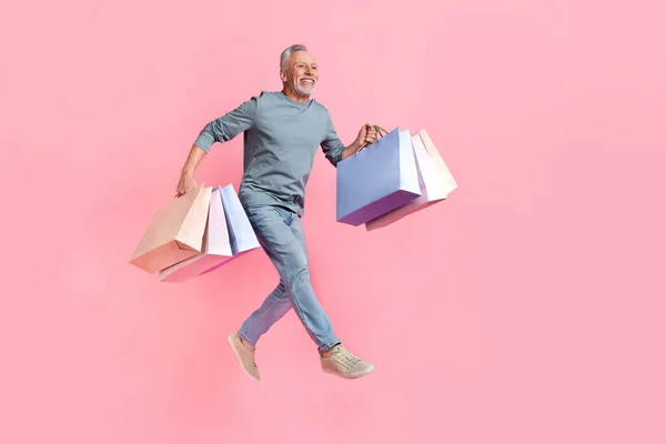 Foto de hombre lindo soñador pensionista vestido camisa gris saltando alto espacio vacío aislado color rosa fondo — Foto de Stock